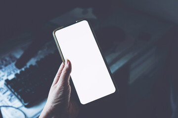 Hand holding an android smart phone in an office