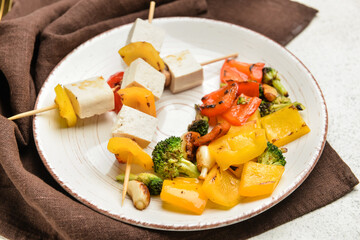 Plate with grilled tofu cheese skewers on light background, closeup
