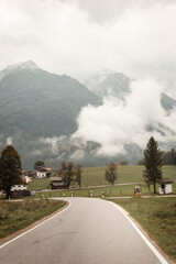 Obraz premium Beautiful village by the foggy mountains