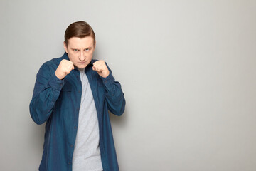 Portrait of mature man holding clenched fists in front of him