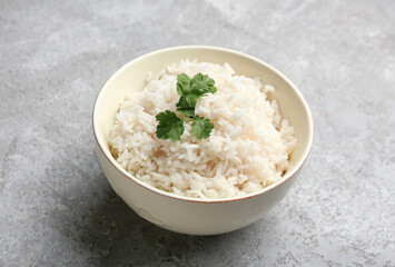 Bowl with tasty boiled rice on grey background, closeup