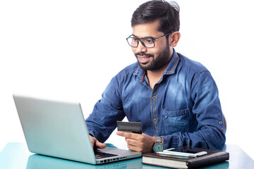 man smiling and shopping online and making online payment on laptop