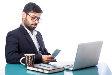 distracted lawyer busy with mobile phone sitting in front of laptop in isolated background