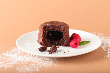 Plate with tasty lava cake fondant and raspberry on color background, closeup