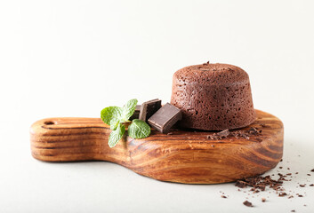 Board with tasty lava cake fondant and mint on white background