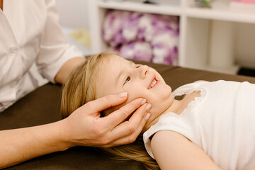 Obraz na płótnie Canvas real doctor osteopath hands does physiological and emotional therapy for four year old kid girl. pediatric osteopathy treatment session. alternative medicine. taking care of the child's health
