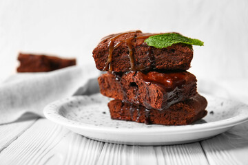 Plate with pieces of tasty chocolate brownie on table