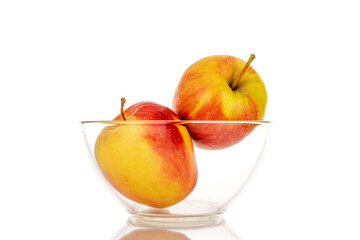 Two red juicy apples in a glass bowl, macro, isolated on white.