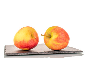 Two red juicy apples on a slate stone, macro, isolated on white.