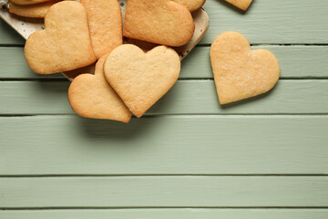 Plate with tasty heart shaped cookies on green wooden background. Valentines Day celebration