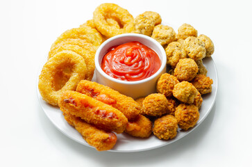 Southern fried and roast chicken bites, onion rings and mozzarella stick served on the white plate with tomato sauce