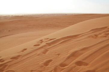 Fototapeta na wymiar Sand. Desert without people. Traces of people and cars in the sand. Drought. Tourism. Dubai