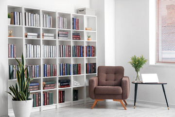 Bookcase with armchair in modern interior of room