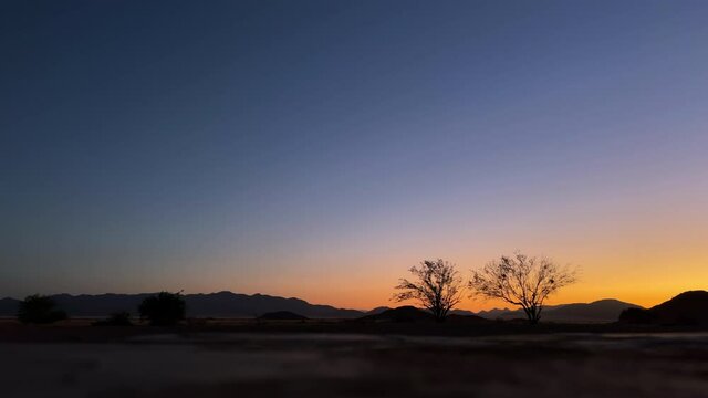 Sunset in desert in Namibia, Africa. Timelapse. Orange blue sky time lapse dawn.