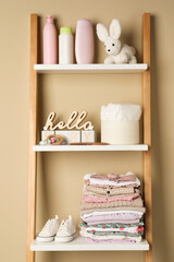 Baby clothes, toy and accessories on wooden rack