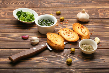 Tasty croutons with spices on wooden background