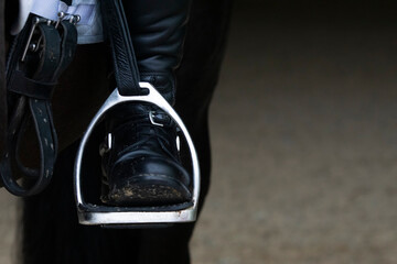 Detail of a stirrup and boot in dressage - obrazy, fototapety, plakaty