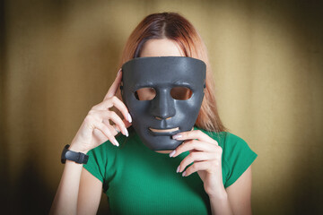 Young woman holding black mask. Fake, anonymous