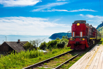 Landscape for travel with the arrival of a red train on a wooden deserted platform Circum-Baikal...