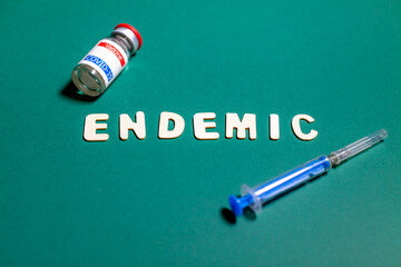 endemic sign on green background with vaccine and syringe