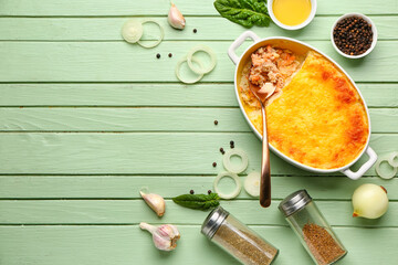 Baking dish with tasty English fish pie on green wooden background