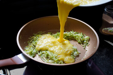 Preparing an omelet with zucchini and cheese. Homemade and organic food - 481894753