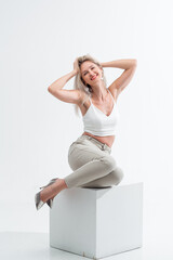 Fototapeta na wymiar Beautiful blonde in jeans in the studio on a light background.