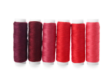 Different sewing thread spools on white background