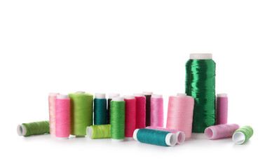 Different sewing thread spools on white background