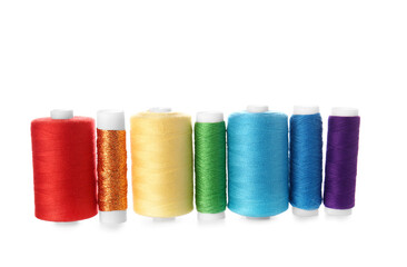 Different sewing thread spools on white background