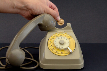 old vintage wheel phone and hand with telephone token.