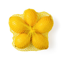 Ripe organic bio lemons in a yellow mesh bag isolated on white background. Net sack of fresh citruses close-up. Buying packaged fruits, lemon bag concepts.