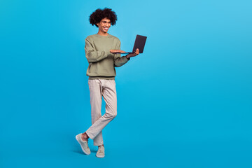 Full length photo of young guy use laptop chat type speak presentation expert isolated over blue color background