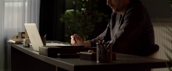 CU Portrait of 40s Thoughtful Caucasian businessman working on a laptop in the office. Shot with 2x...