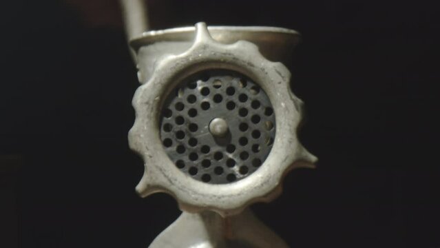 Zoom Out Shot Of Manual Meat Grinder In Dark Studio. Unrecognizable Man Turning Hand Crank