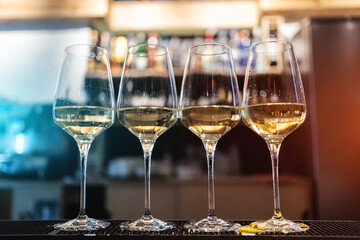 closeup of elegant wineglass with white wine or alcohol drink at restaurant bar
