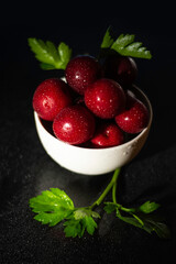 Plums served on a plate decorated with fine herbs in low key