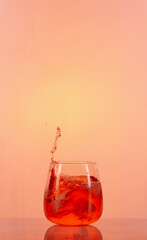 salpicadura de agua con cubitos de hielo en vaso de vidrio