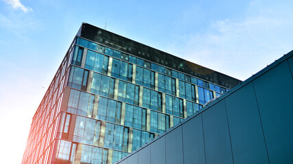 Modern glass corporate architecture with reflection of sky on the facade a sunny day - obrazy, fototapety, plakaty