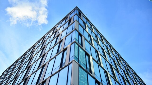 Modern glass corporate architecture with reflection of sky on the facade a sunny day