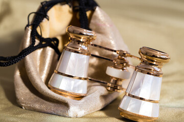 Selective focus macro photo of vintage mother-of-pearl and metal opera glasses with their case
