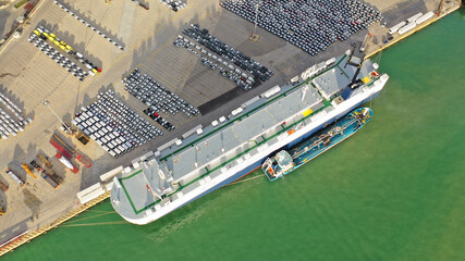 Aerial drone top down photo of large car carrier ro ro vessel anchored in car terminal of Mediterranean port