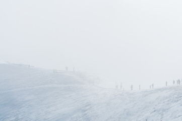 Tatra Mountains. People walking on a ridge shrouded in a cloud.