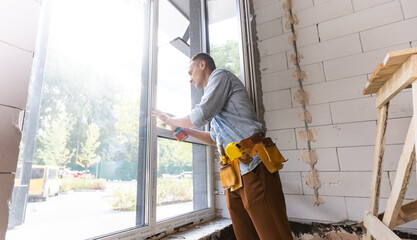 Fototapeta premium Construction worker installing window in house