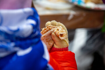 little girl eating pancake blini at maslenitsa festival