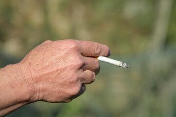 Elderly woman hold burning cigarette while smoking,tobacco smoke,unhealthy skin damage lifestyle