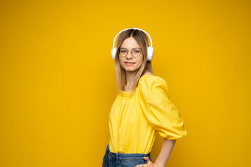 Pretty young woman girl in yellow t-shirt listen music with headphones.