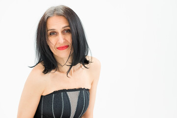 Naklejka premium Studio photo of middle aged woman starting getting grey-haired wearing black and white clothes on white background, middle age sexy lady, happy life concept
