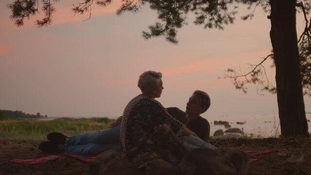 Cinematic beautiful evening shot of young millennial couple in love laugh and smile. Romantic genuine date, mindful and healthy relationship, loving gentle cuddle. Couple in love