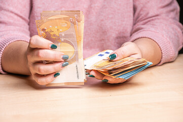 business, finance, saving, banking and people concept - close-up of woman hands counting euro money